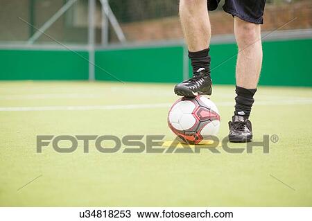 Young man on urban football pitch, foot on football, low section View Large Photo Image Stock Image - Young man on urban football pitch, foot on football, low section. Fotosearch
