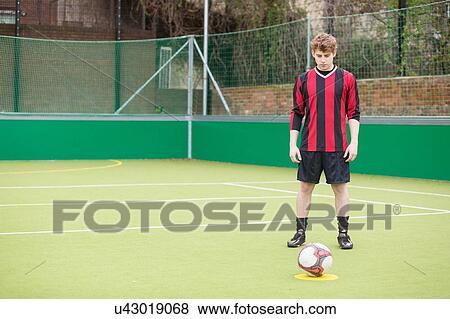 Young man on urban football pitch View Large Photo Image Stock Photo - Young man on urban football pitch. Fotosearch