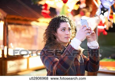 Young woman at amusement park using smartphone to take selfie View Large Photo Image Stock Photo - Young woman at amusement park using smartphone to take selfie. Fotosearch