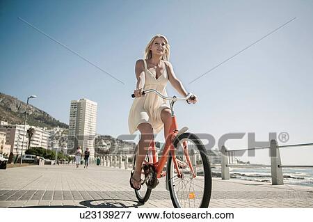 Young woman cycling on seafront, Cape Town, South Africa View Large Photo Image Stock Photo - Young woman cycling on seafront, Cape Town, South Africa. Fotosearch