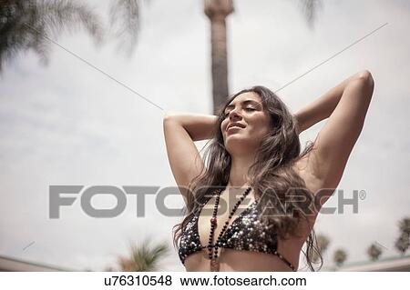 Stock Photo - Young woman in bikini enjoying fresh air. Fotosearch