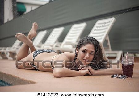 Young woman in bikini relaxing beside deck chairs View Large Photo Image Stock Image - Young woman in bikini relaxing beside deck chairs. Fotosearch