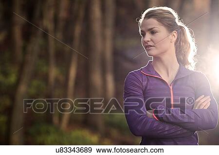 Young woman in forest arms folded looking away View Large Photo Image Stock Photo - Young woman in forest arms folded looking away. Fotosearch