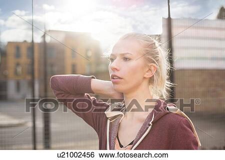 Stock Photograph - Young woman looking away, outdoors. Fotosearch