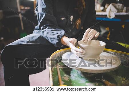 Young woman sitting at pottery wheel making clay pot View Large Photo Image Stock Photography - Young woman sitting at pottery wheel making clay pot. Fotosearch