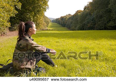 Young woman sitting in field looking at landscape, Great Missenden, Buckinghamshire, U. K View Large Photo Image Stock Photo - Young woman sitting in field looking at landscape, Great Missenden, Buckinghamshire, U. K. Fotosearch