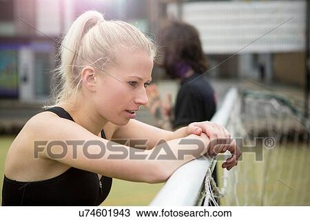 Young woman taking a break, leaning on football goal View Large Photo Image Stock Image - Young woman taking a break, leaning on football goal. Fotosearch