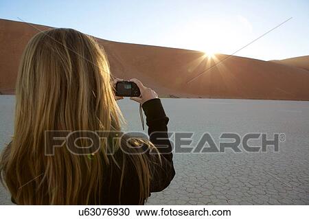 Young woman taking photograph of dead vlei sunset. rear view, Sossusvlei, Hardap, Namibia View Large Photo Image Stock Image - Young woman taking photograph of dead vlei sunset. rear view, Sossusvlei, Hardap, Namibia. Fotosearch