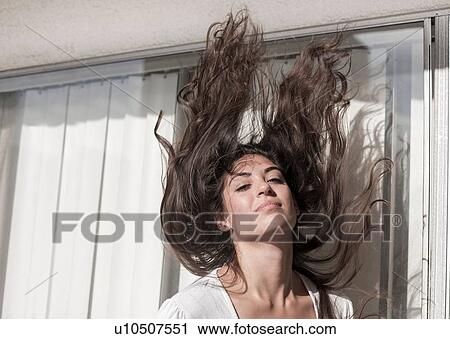 Young woman throwing hair back, in front of sliding doors View Large Photo Image Stock Image - Young woman throwing hair back, in front of sliding doors. Fotosearch