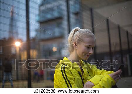 Young woman using smartphone, smiling View Large Photo Image Stock Photo - Young woman using smartphone, smiling. Fotosearch