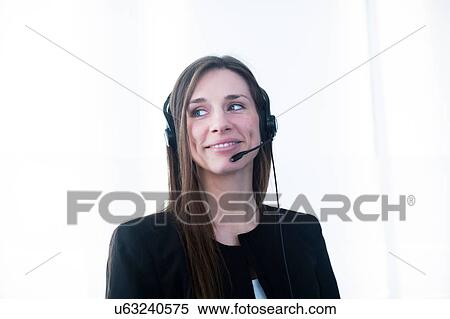 Young woman wearing telephone headset looking away smiling View Large Photo Image Stock Photography - Young woman wearing telephone headset looking away smiling. Fotosearch