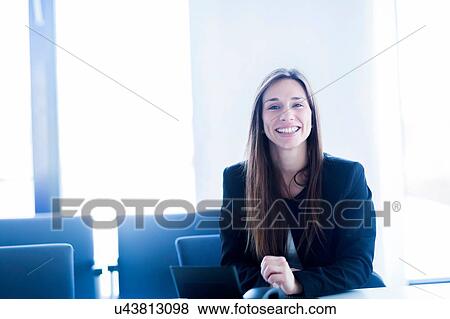 Young woman with digital tablet sitting looking at camera smiling View Large Photo Image Stock Photo - Young woman with digital tablet sitting looking at camera smiling. Fotosearch