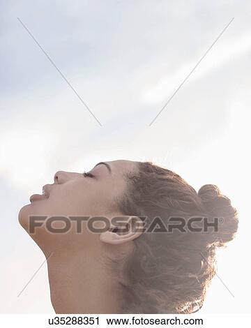 Young woman with hair bun, eyes closed View Large Photo Image Stock Image - Young woman with hair bun, eyes closed. Fotosearch