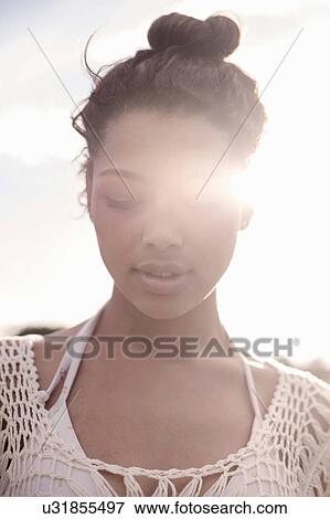 Young woman with hair bun, eyes closed View Large Photo Image Stock Photo - Young woman with hair bun, eyes closed. Fotosearch