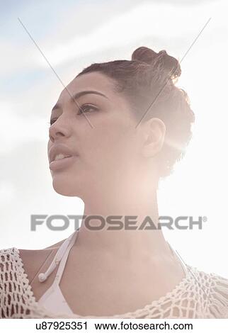 Stock Image - Young woman with hair bun. Fotosearch