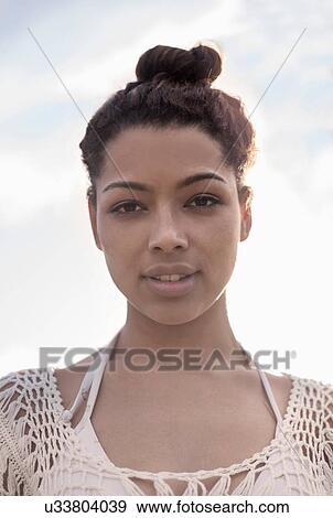 Young woman with hair bun View Large Photo Image Stock Photo - Young woman with hair bun. Fotosearch