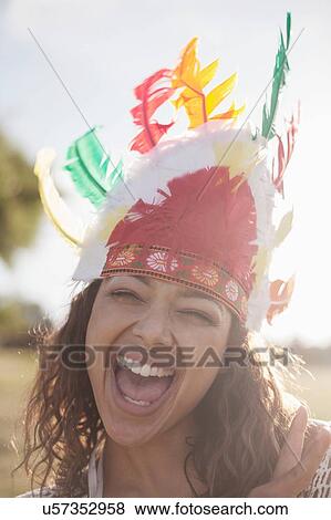 Stock Photo - Young woman with wearing feathered headdress. Fotosearch