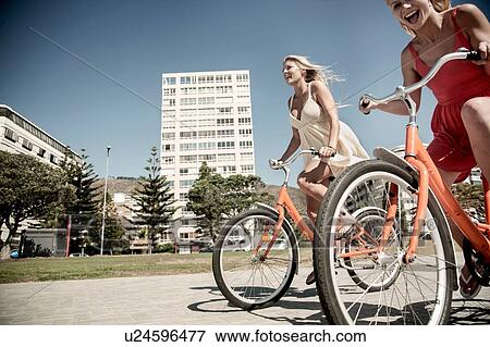 Young women cycling past buildings, Cape Town, South Africa View Large Photo Image Stock Photo - Young women cycling past buildings, Cape Town, South Africa. Fotosearch