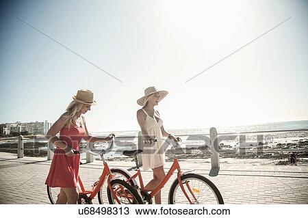 Young women walking with bicycle on seafront, Cape Town, South Africa View Large Photo Image Stock Image - Young women walking with bicycle on seafront, Cape Town, South Africa. Fotosearch