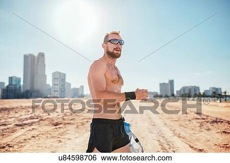 "Barechested man on sand wearing sunglasses by skyscrapers, Dubai, United Arab Emirates" View Large Photo Image Stock Photograph - "Barechested man on sand wearing sunglasses by skyscrapers, Dubai, United Arab Emirates". Fotosearch
