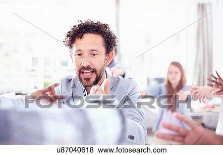 Stock Photo - Bearded mature man in team building talk hands raised smiling. Fotosearch