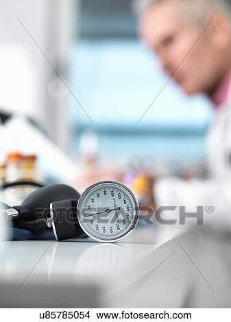 Blood pressure monitor on desk, doctor in background View Large Photo Image Picture - Blood pressure monitor on desk, doctor in background. Fotosearch