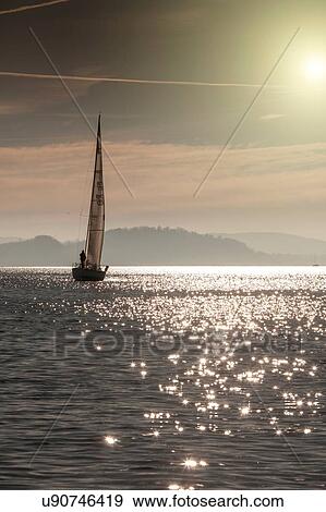 Boat on sparkling water surface, Lake Maggiore, Piedmont, Lombardy, Italy View Large Photo Image Stock Photo - Boat on sparkling water surface, Lake Maggiore, Piedmont, Lombardy, Italy. Fotosearch
