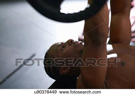 Bodybuilder lifting barbell on floor in gym View Large Photo Image Stock Photo - Bodybuilder lifting barbell on floor in gym. Fotosearch