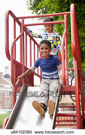 Boy and friends sliding on playground slide View Large Photo Image Stock Photography - Boy and friends sliding on playground slide. Fotosearch