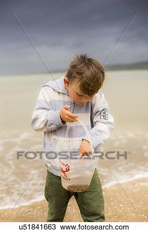Stock Image - Boy holding crab. Fotosearch
