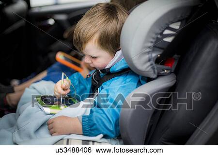 Boy in car using digital device View Large Photo Image Stock Photograph - Boy in car using digital device. Fotosearch