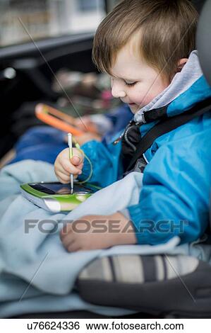 Boy in car using digital device View Large Photo Image Stock Photograph - Boy in car using digital device. Fotosearch