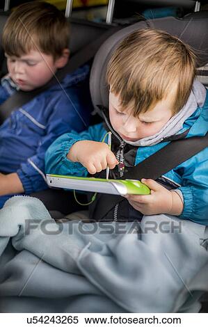 Stock Photography - Boy in car with a digital device. Fotosearch