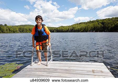 Stock Photo - "Boy on pier by lake, New Milford, Pennsylvania, US". Fotosearch