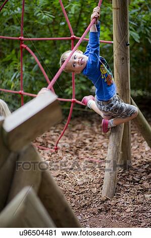 Boy playing on climbing frame View Large Photo Image Stock Image - Boy playing on climbing frame. Fotosearch