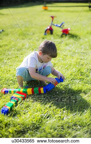 Stock Photography - Boy playing with plastic bricks. Fotosearch