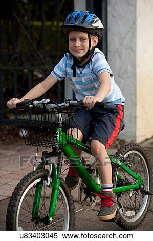 Stock Photography - Boy riding bicycle on pavement. Fotosearch