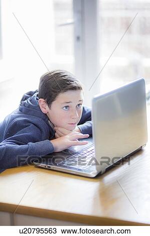 Boy using a laptop View Large Photo Image Stock Image - Boy using a laptop. Fotosearch