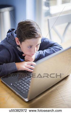 Stock Image - Boy using a laptop. Fotosearch