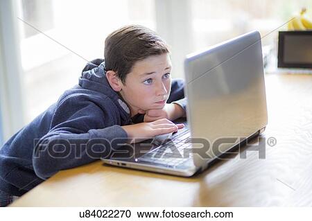 Stock Image - Boy using a laptop. Fotosearch