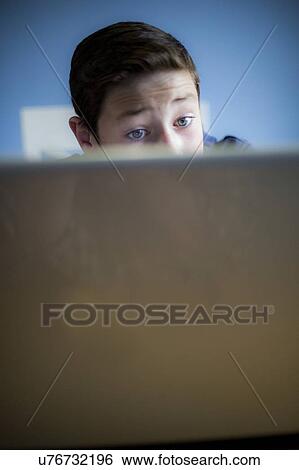 Boy using a laptop View Large Photo Image Stock Photograph - Boy using a laptop. Fotosearch