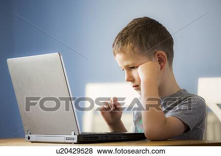 Stock Photo - Boy using laptop. Fotosearch