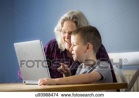 Boy using laptop with grandmother View Large Photo Image Picture - Boy using laptop with grandmother. Fotosearch