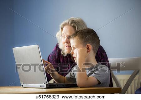 Boy using laptop with grandmother View Large Photo Image Stock Photo - Boy using laptop with grandmother. Fotosearch