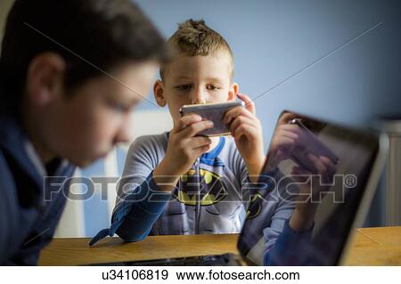 Boy using smartphone View Large Photo Image Stock Photo - Boy using smartphone. Fotosearch
