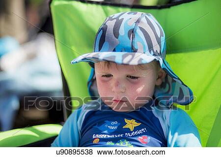 Stock Photo - Boy wearing a sun hat and uv clothing. Fotosearch