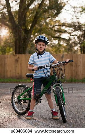 Picture - Boy with bicycle on road. Fotosearch