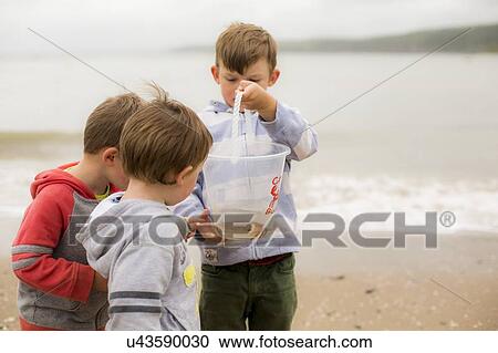 Stock Image - Boys holding crab. Fotosearch