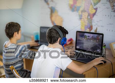 Stock Image - Boys using laptop. Fotosearch