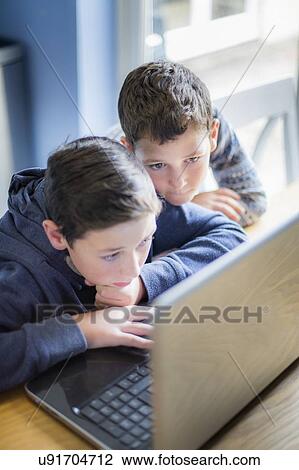Stock Image - Boys using laptop. Fotosearch